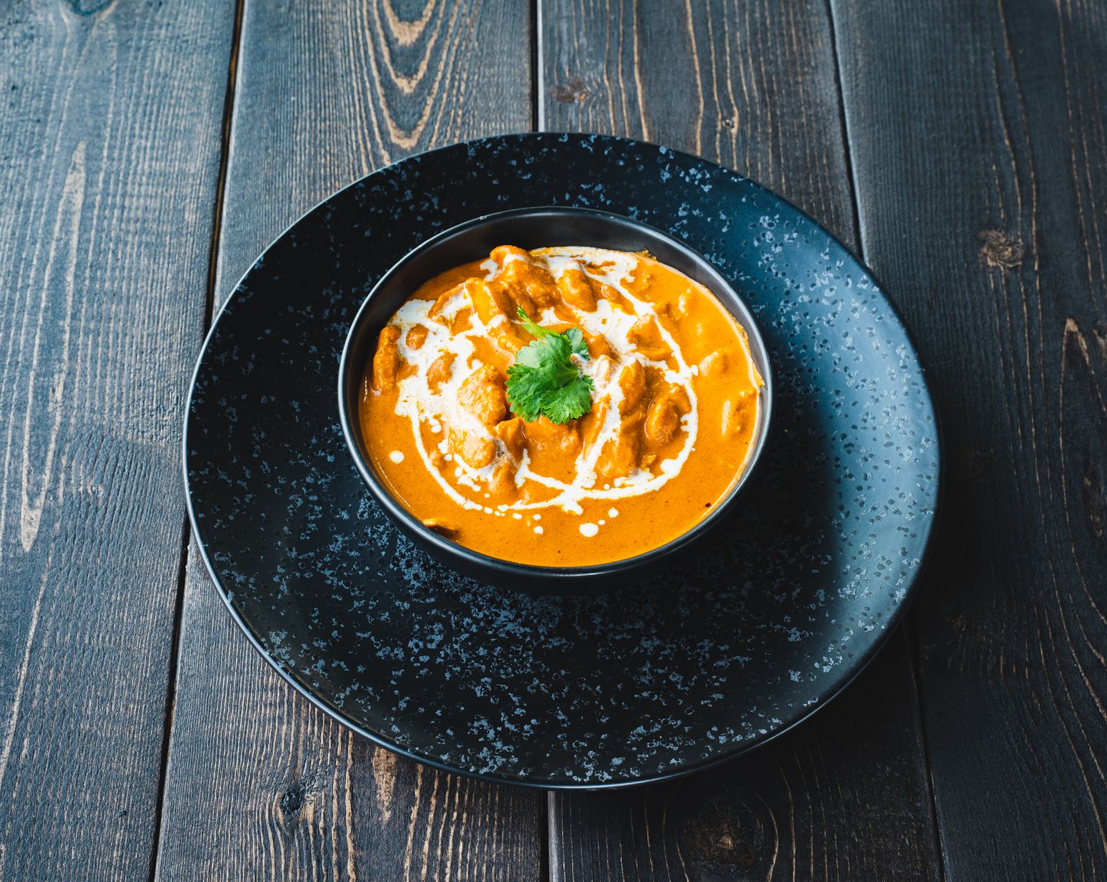 A bowl of creamy curry topped with coriander